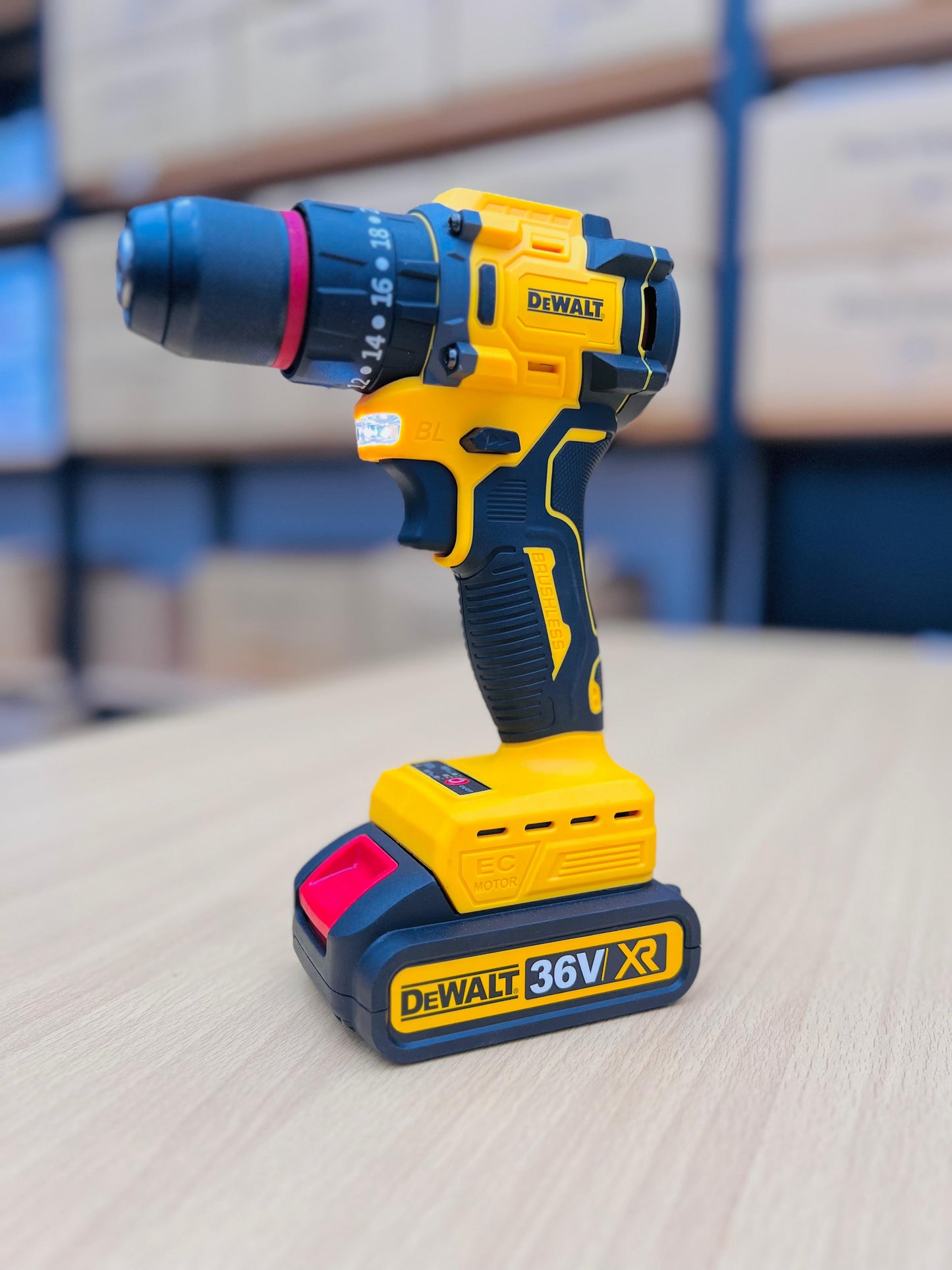 Yellow and black DEWALT cordless drill on a light surface with a blurred background