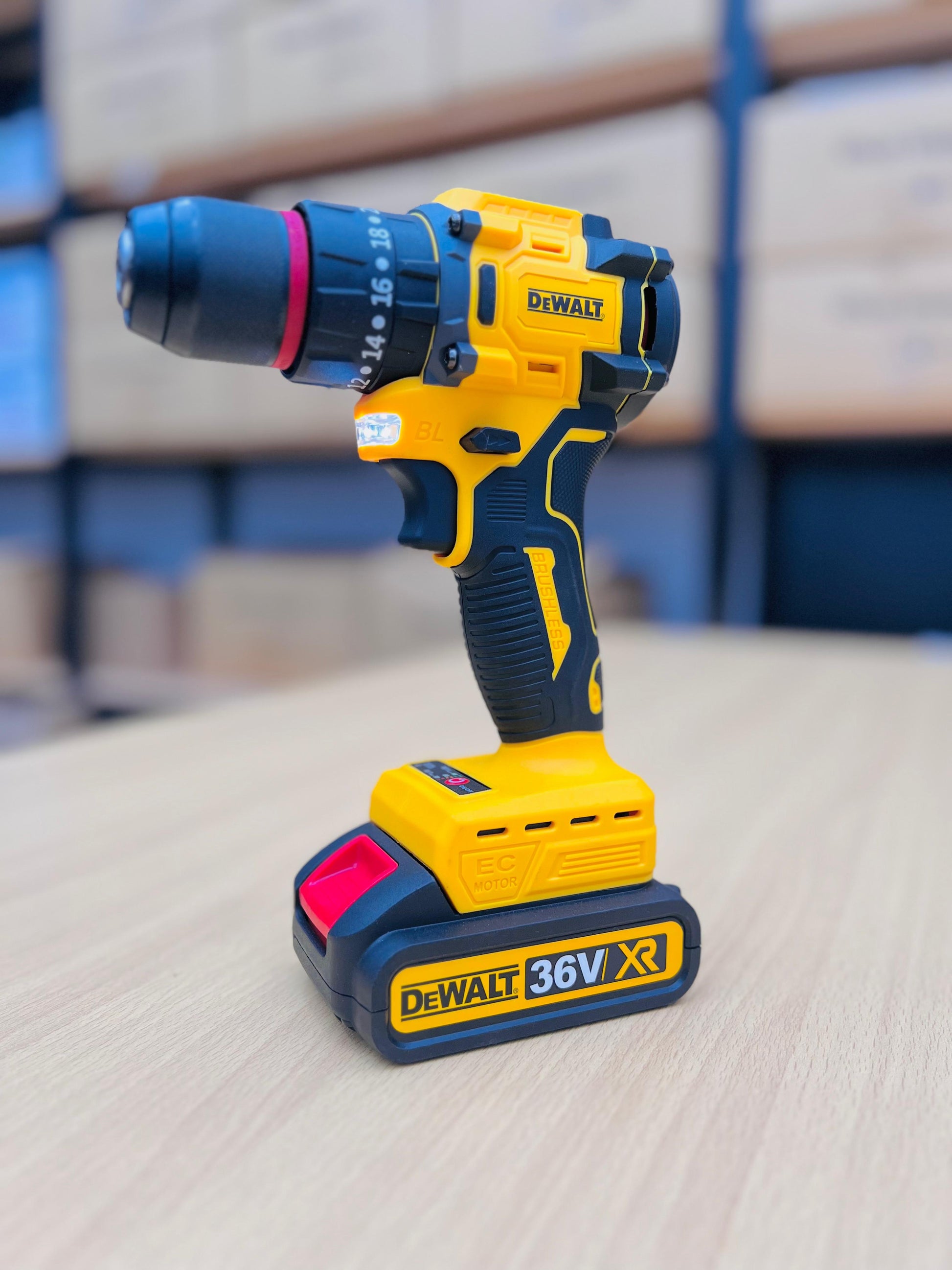Yellow and black DEWALT cordless drill on a light surface with a blurred background